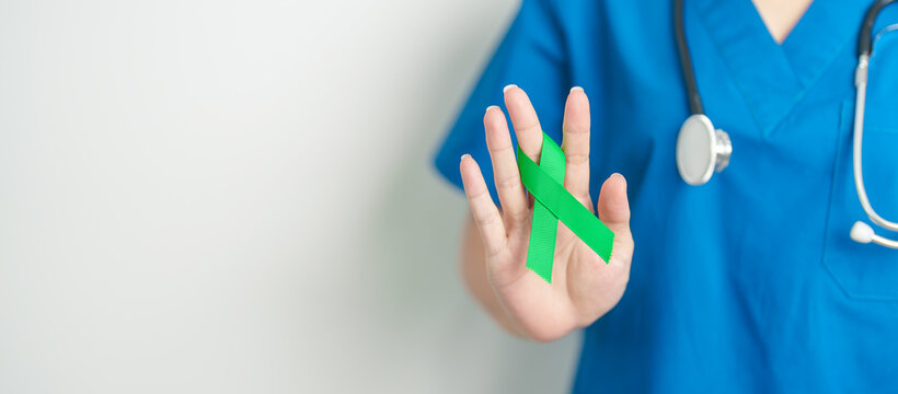 Doctor with green Ribbon for world Lymphoma Awareness September month, world Mental Health Day, Liver, Gallbladders, bile duct, cervical, kidney Cancer. Healthcare and world cancer day concept