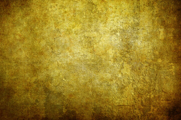 A highly detailed golden grunge texture with a rough, distressed surface. The image features various shades of gold and brown, with visible scratches and worn-out areas, ideal for use as a background 