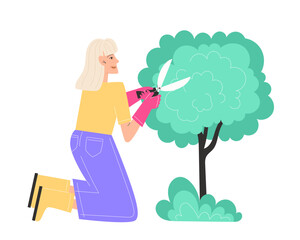 A elderly woman trims bushes in the garden with garden shears