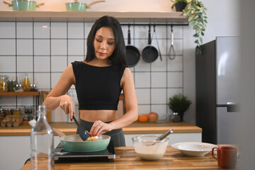 Young woman woman preparing a healthy meal on wooden countertop Healthy eating, culinary and...