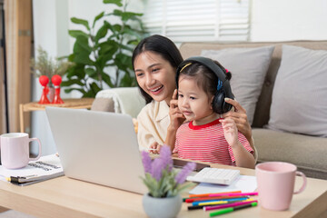 Mother and daughter enjoying music together on laptop