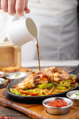 Shrimp fajitas on wooden table with sauces and tortillas on the side