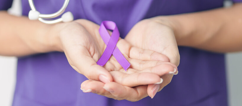 Doctor holding purple Ribbon for Violence, Pancreatic, Esophageal, Testicular cancer, Alzheimer, epilepsy, lupus, Sarcoidosis and Fibromyalgia. Awareness month and World cancer day concept
