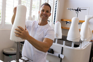 Working in prosthetic lab, man crafting prosthetic limbs with precision and care