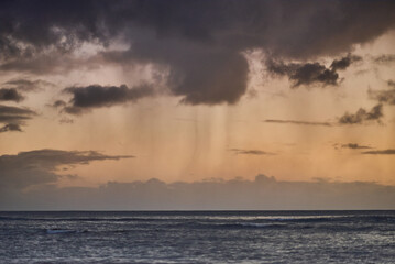 Beautiful clouds with rain during sunset over the ocean