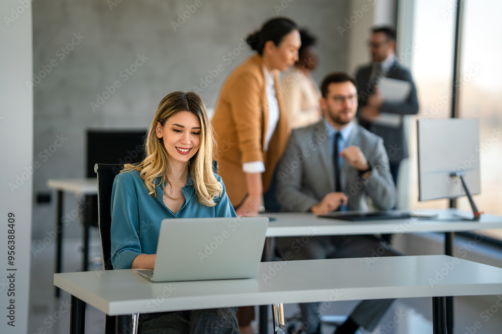 Canvas Prints Young happy successful business woman working with laptop in corporate office