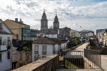 Scenic view of historic buildings and the towers of the cathedral in Lugo, Spain, during a sunny day with clouds