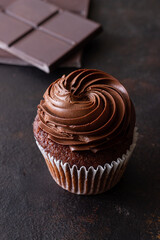 Chocolate cupcake on brown background. Dessert. Cooking. Baking. Vegetarian food.
