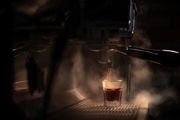 Espresso machine brewing coffee into a glass.