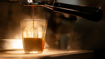 Espresso machine brewing coffee into a glass.