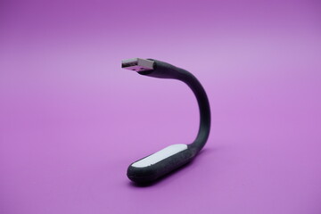 black usb lamp isolated purple background. versatile USB lamp that can be turned on by connecting to a USB port.
