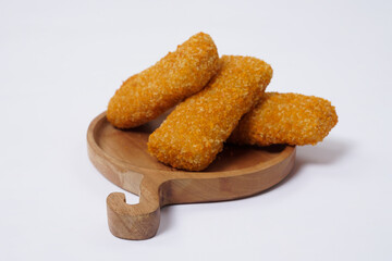 American Risoles or risoles mayo is a traditional Indonesian snack filled with smoked beef or sausage, boiled eggs & mayonnaise. Crispy texture on the outside. Risoles on wood plate isolated white.