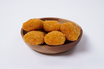 American Risoles or risoles mayo is a traditional Indonesian snack filled with smoked beef or sausage, boiled eggs & mayonnaise. Crispy texture on the outside. Risoles on wood plate isolated white.
