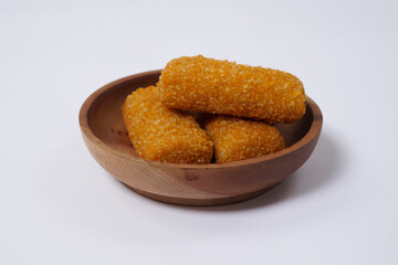 American Risoles or risoles mayo is a traditional Indonesian snack filled with smoked beef or sausage, boiled eggs & mayonnaise. Crispy texture on the outside. Risoles on wood plate isolated white.
