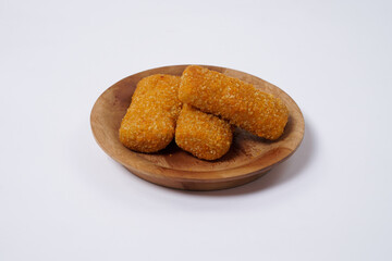 American Risoles or risoles mayo is a traditional Indonesian snack filled with smoked beef or sausage, boiled eggs & mayonnaise. Crispy texture on the outside. Risoles on wood plate isolated white.