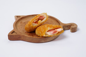 American Risoles or risoles mayo is a traditional Indonesian snack filled with smoked beef or sausage, boiled eggs & mayonnaise. Crispy texture on the outside. Risoles on wood plate isolated white.