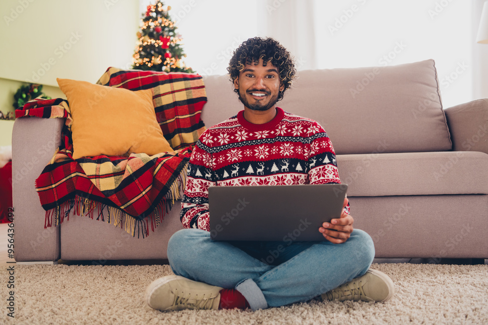 Wall mural Full body portrait of nice young man use laptop carpet floor wear xmas sweater holiday atmosphere flat indoors