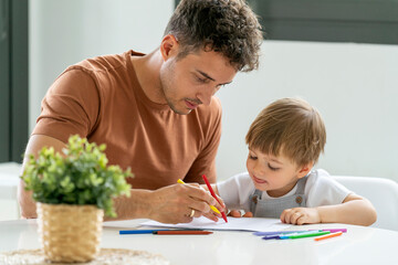 Father and Son Concentrating on Drawing Together, Sharing a Creative Moment