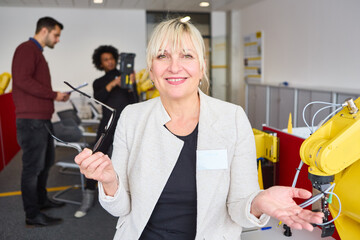 Professionals in a robotics training facility with a robot arm, discussing technical innovation