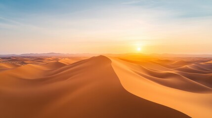 Aerial a vast desert landscape with rolling sand dunes and the setting sun casting a golden hue over the horizon