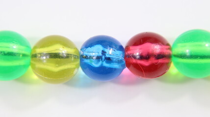 Concentrati sul primo piano della collana di plastica con sfere colorate su sfondo bianco