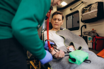 A woman's pulse is taken in an ambulance © Roman