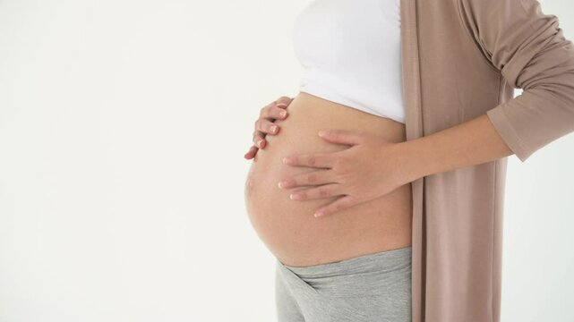 pregnant woman applying moisturizing, stretch mark cream on belly