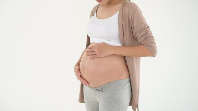 pregnant woman applying moisturizing, stretch mark cream on belly