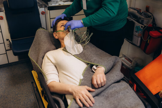 Paramedic using oxygen mask to help unconscious woman
