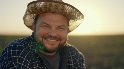 Emotional farmer in straw hat looking at camera and smiling broadly, portrait. Hispanic male person rejoicing by good harvest of corn and soya, successful agronomist in beautiful agricultural field