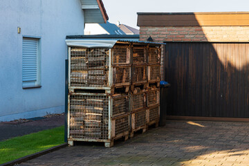 Firewood for the fireplace in metal containers in front of the garage
