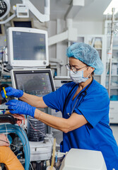 Medical professional administers care in a modern hospital setting. A skilled healthcare worker in scrubs attends to a patient in an intensive care unit