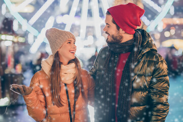 Photo of loving couple talking under evening x-mas night illumination outside sky wear season coats scarf