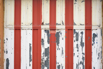 Puerta de garage de rayas blancas y rojas deteriorada