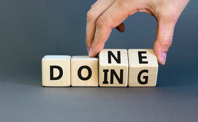 Doing and done symbol. Concept words Doing Done on wooden block. Beautiful grey table grey background. Businessman hand. Business doing and done concept. Copy space. © Dzmitry