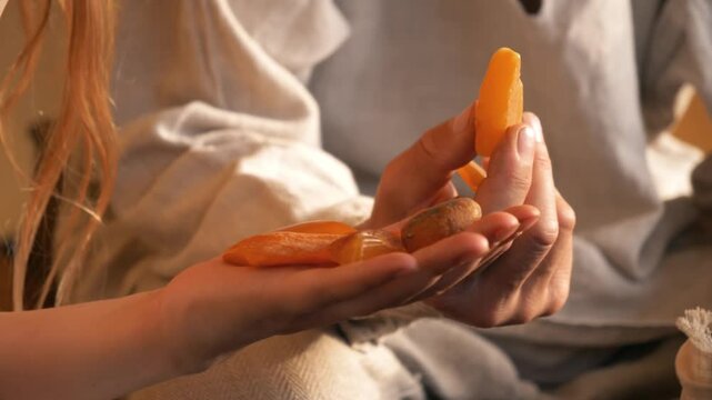 Closeup of an ancient Baltic man and woman holding and examining amber. Culture of the Baltics. Historical reenactment. Rumsiskes, Lithuania- 07 05 2024. 