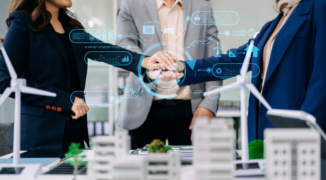 Group of diverse multiethnic businesspeople standing neare table looking at model of building from residential project.