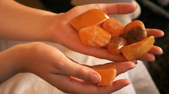Closeup of an ancient Baltic man and woman holding and examining amber. Culture of the Baltics. Historical reenactment. Rumsiskes, Lithuania- 07 05 2024. 