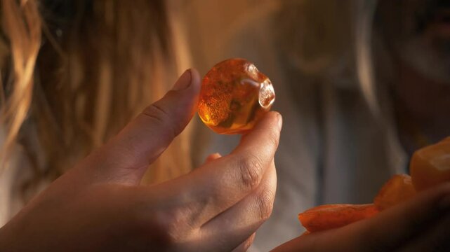 Closeup of an ancient Baltic man and woman holding and examining amber. Culture of the Baltics. Historical reenactment. Rumsiskes, Lithuania- 07 05 2024. 
