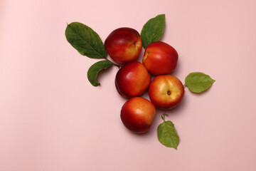 Ripe nectarines on a pink background with copy space. Flat lay, top view of fresh fruit on a table. Healthy eating concept. 