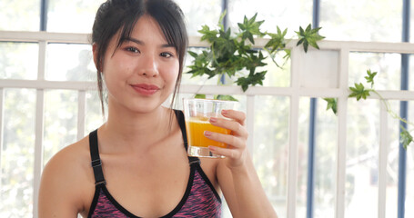 Women hands holding cold orange juice fresh fruit cool drinking. Asian women smile laugh look at camera health care home fitness lifestyle. Beautiful female pouring orange juice from cocktail bottle