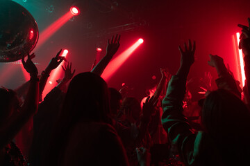 Group of men and women enjoying dancing at party in club, Dj standing in the middle of the crowd
