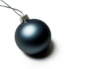A minimalistic photo of a single Christmas tree ornament with matte black finish on a white background with big copy space.
