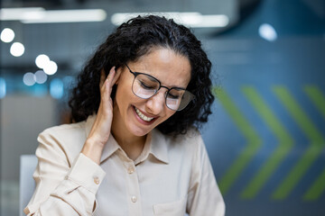 A woman at the workplace inside the office has a severe pain in her ear, the office worker is sick,...