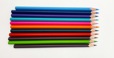 Colorful sharpened pencils are lined up on the table.