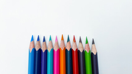 Colorful sharpened pencils are lined up on the table.