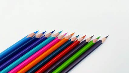 Colorful sharpened pencils are lined up on the table.