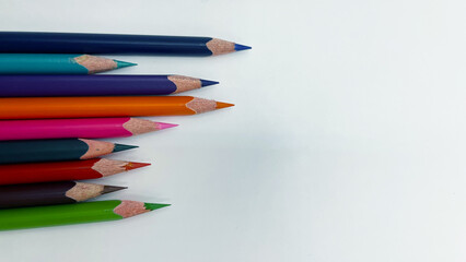 Colorful sharpened pencils are lined up on the table.