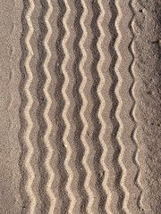 Tire tread marks on the sand, straits imprints from wheels on the surface of the dunes