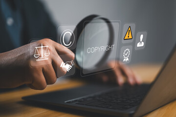 Copyright or patent concept. Author rights and patented intellectual property. copyleft trademark license. Businessman use laptop with copyright icon on virtual screen.
